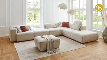 Großes Ecksofa mit vielen Kissen und Decke als Dekoration